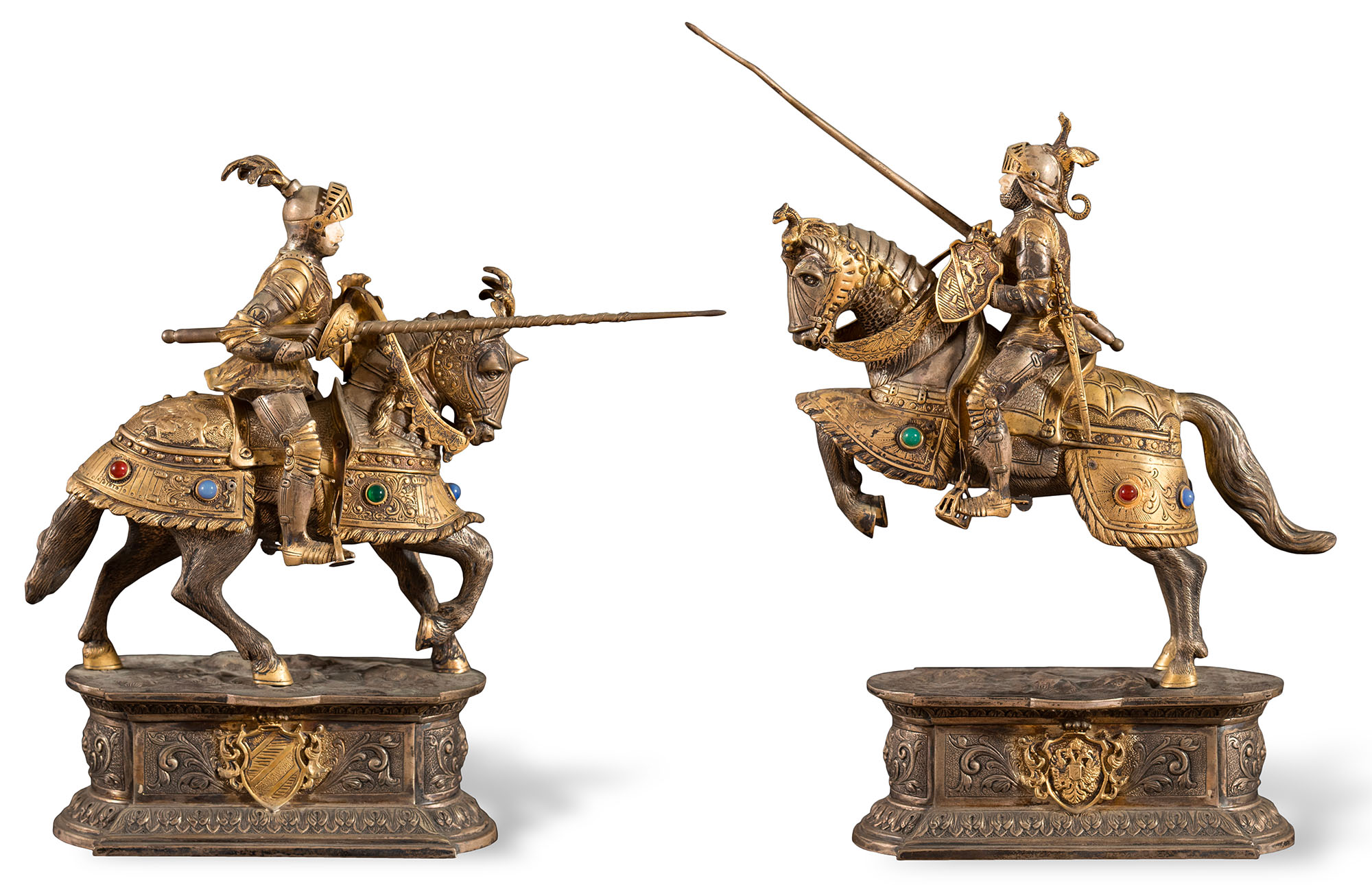 Coppia di sculture in argento sbalzato raffiguranti “Cavalieri in armatura con lancia da giostra”, volti in avorio, armature dei cavalieri e dei cavalli parzialmente dorate e decorate da pietre dure.
