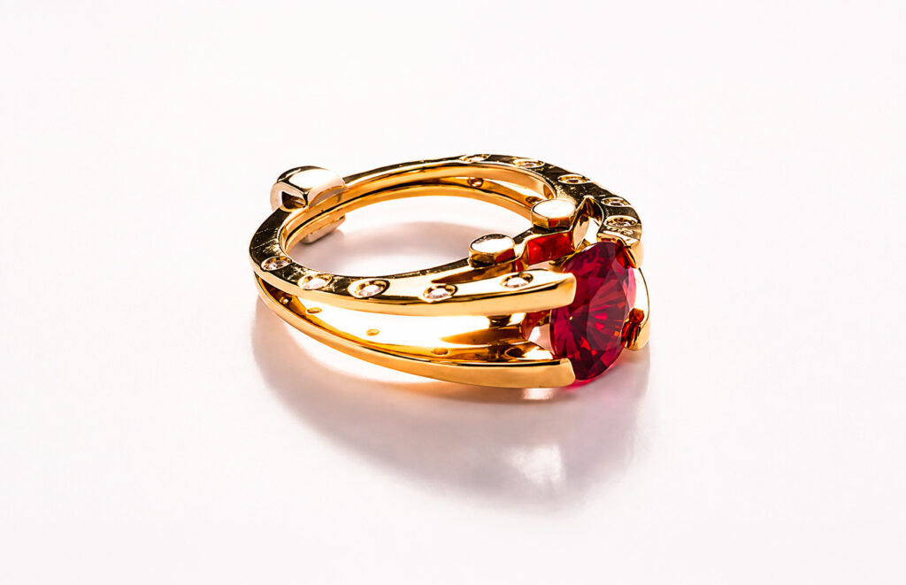 Anello Gino Fontana della collezione Flash in oro giallo con spinello rosso ovale e diamanti taglio brillante.
