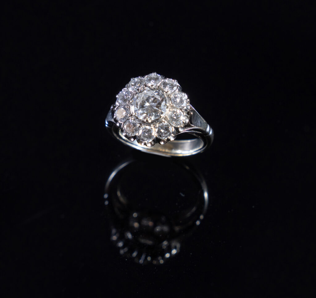 Anello a margherita in oro bianco con diamante centrale da 2 carati e dieci diamanti disposti a raggiera.