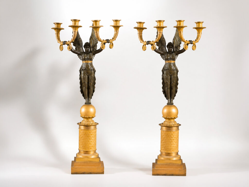 Coppia di candelabri Impero in bronzo dorato e bronzo patinato con Vittoria Alata, Francia, inizi XIX secolo.