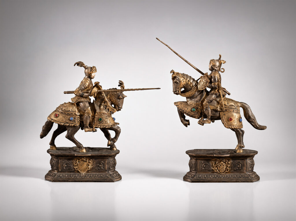 Coppia di sculture in argento sbalzato raffiguranti cavalieri in armatura con lancia da giostra, XX secolo.