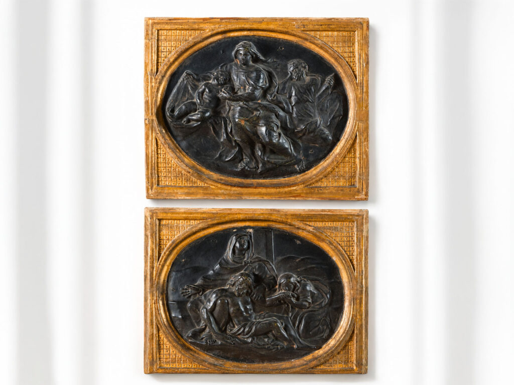 Coppia di pannelli ad altorilievo in cartapesta con scene sacre entro cornici lignee dorate, XVIII secolo.