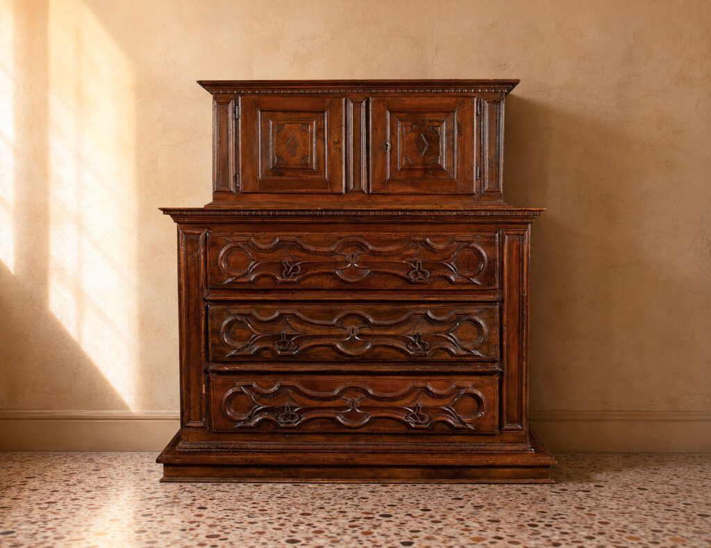 Credenza a doppio corpo in massello di noce, Liguria, metà del XVII secolo, con parte superiore a due ante e parte inferiore a tre cassetti. Trattata da Gregory's Casa d'Aste Bologna, prima casa d'aste di Bologna dal 2013.