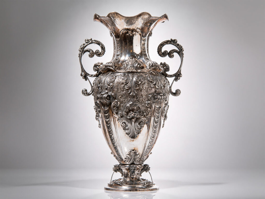 Grande vaso in argento sbalzato con decori a foglie, conchiglie e prese fogliacee, Alessandria, XX secolo.