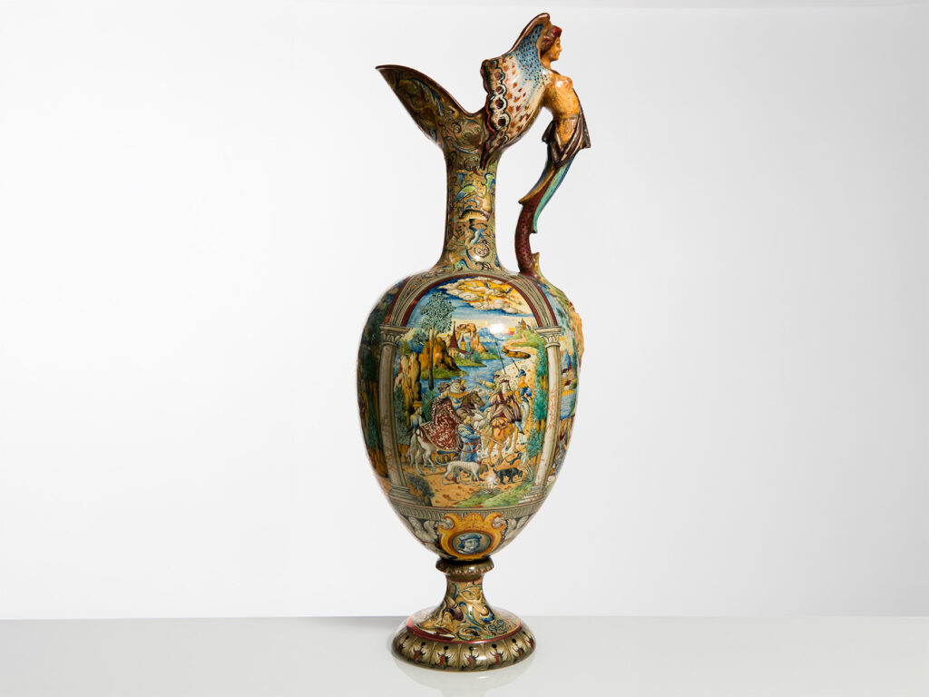 Grande versatoio in ceramica policroma della Manifattura Cantagalli con scene istoriate rinascimentali e presa a figura femminile fantastica.