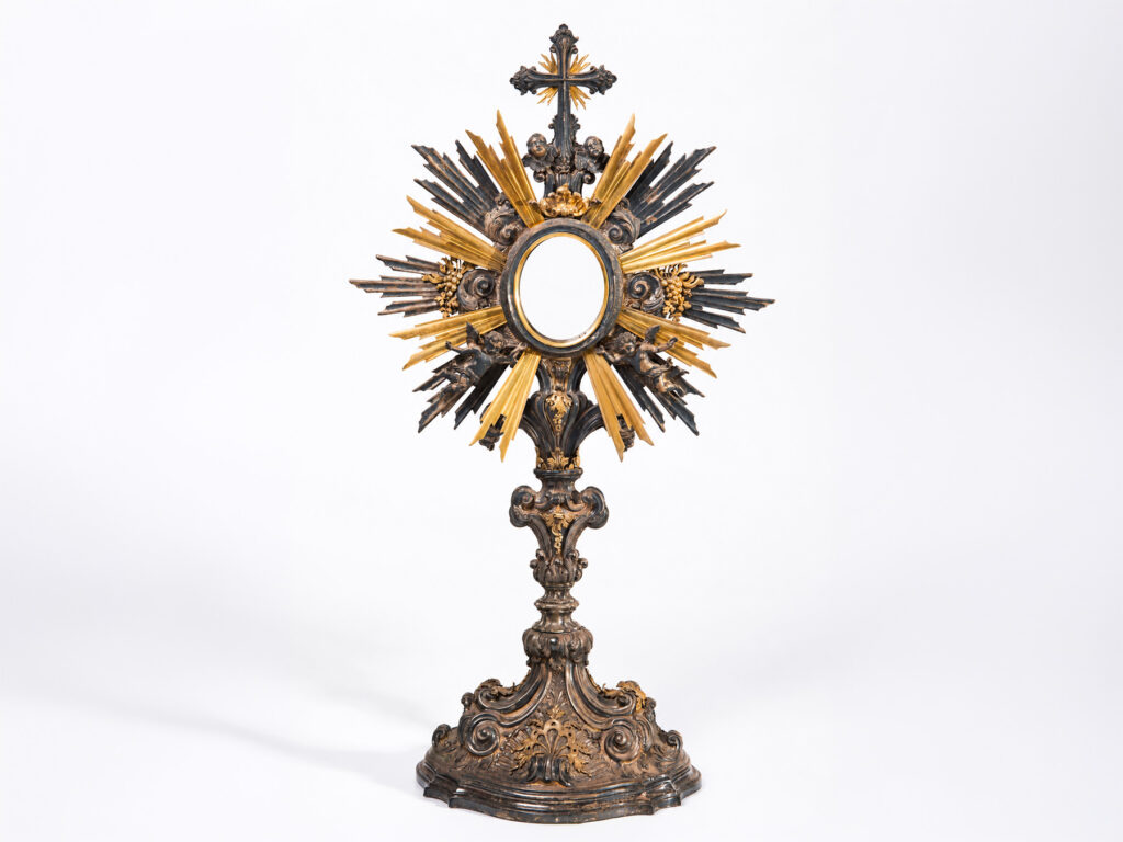 Ostensorio in argento cesellato e parzialmente dorato con raggiera decorata da grappoli d'uva e putti, Italia, fine XVIII - inizio XIX secolo.
