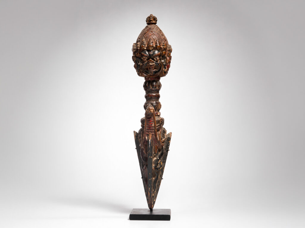 Phurba rituale nepalese in legno scolpito con impugnatura raffigurante una divinità irata, fine XIX – prima metà XX secolo.
