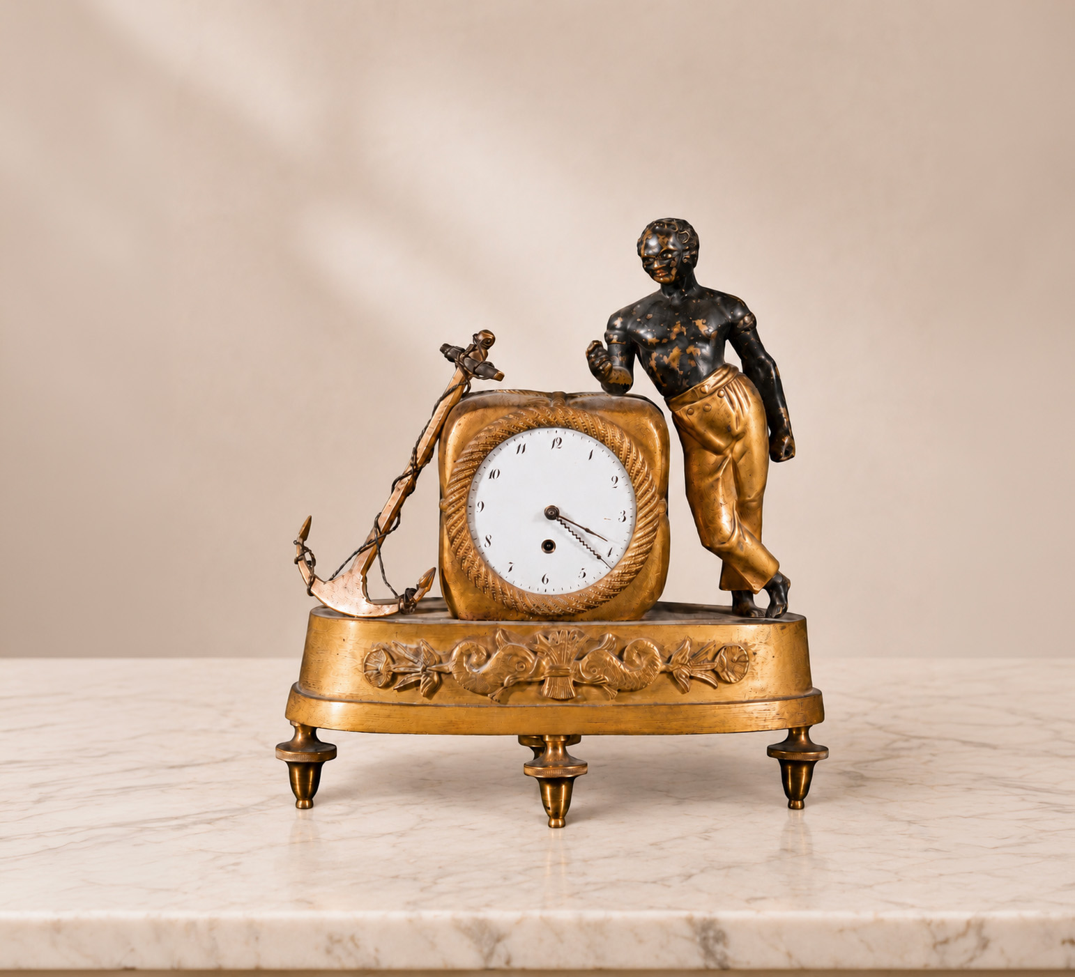 Piccolo orologio da tavolo in bronzo dorato con Moro in bronzo patinato, ancora e quadrante bombato firmato Rigaud Genève, fine XVIII - inizio XIX secolo.