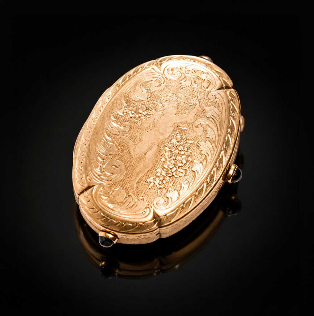 Porta-ritratto porta-pillole in oro giallo inciso con due zaffiri cabochon, anni Quaranta-Cinquanta.