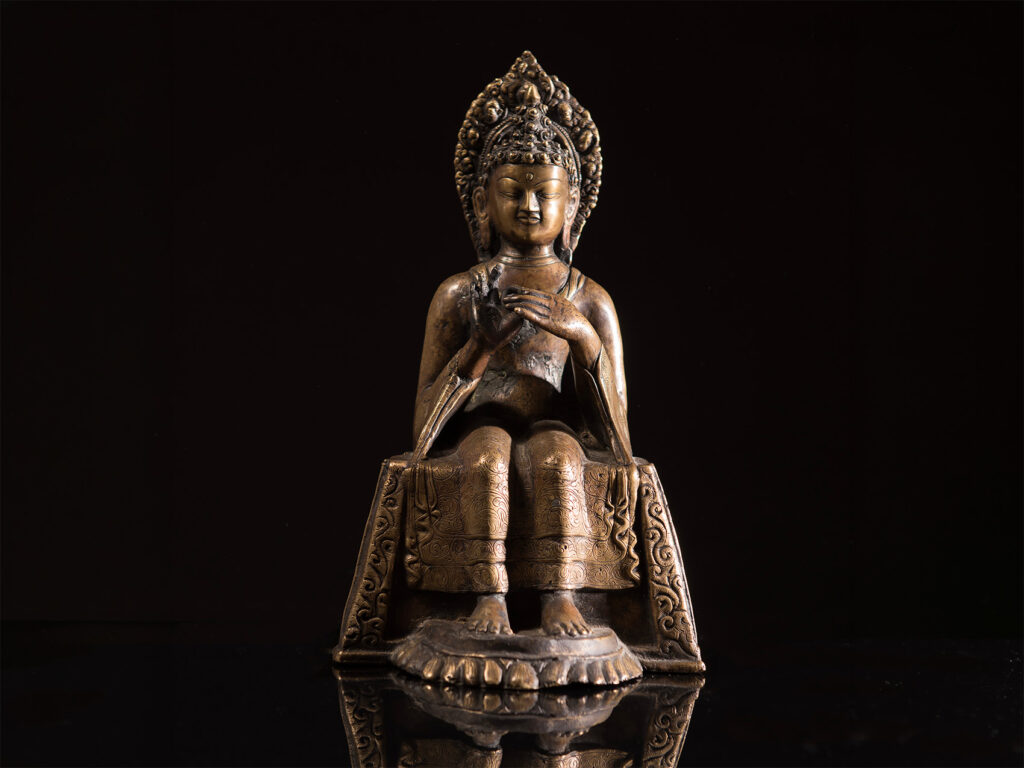 Scultura nepalese in bronzo raffigurante una divinità buddhista seduta in trono, XVIII secolo.