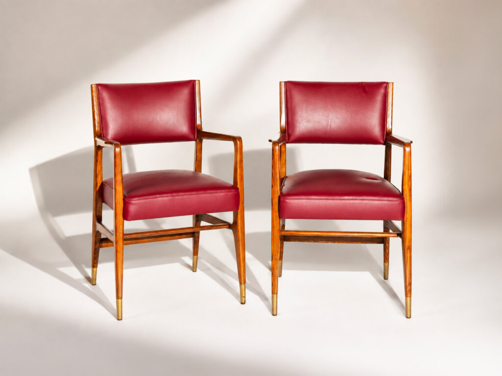 Gio Ponti per Cassina, coppia di sedute con braccioli in legno, rivestimento in skai rosso e puntali in ottone.
