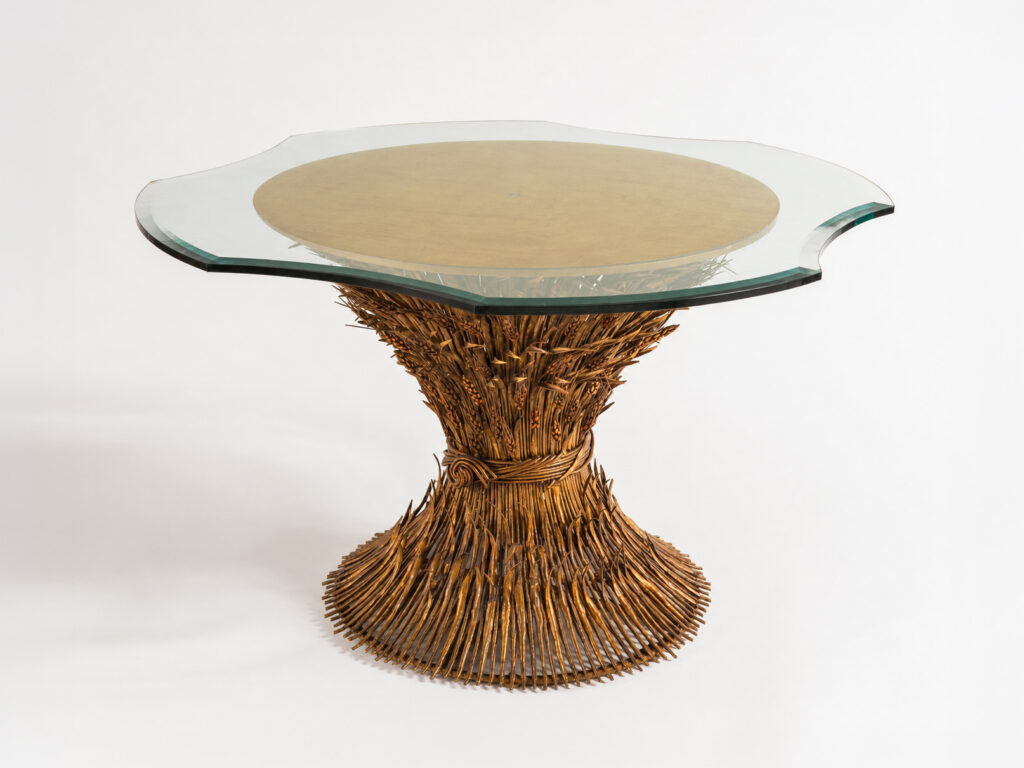 Tavolo "Gerbe de blé" attribuito a Robert Goossens con base in ferro battuto dorato a fascio di spighe e piano in vetro con foglia d'oro.